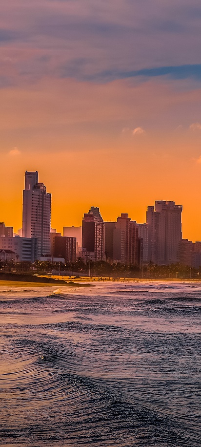 a sunset view of the Durban skyline from the Golden Mile beach in South Africa
