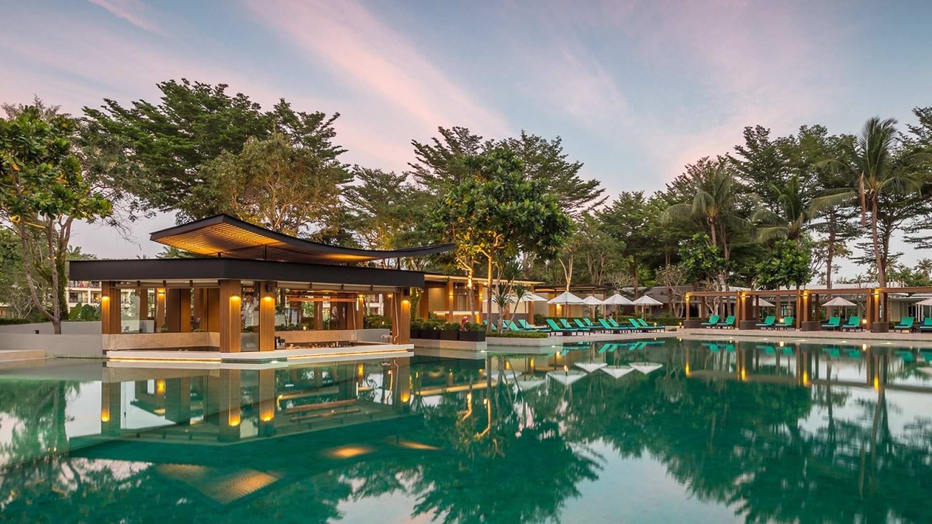 a tranquil evening view of the main swimming pool at the Dusit Thani Krabi Beach Resort in Thailand
