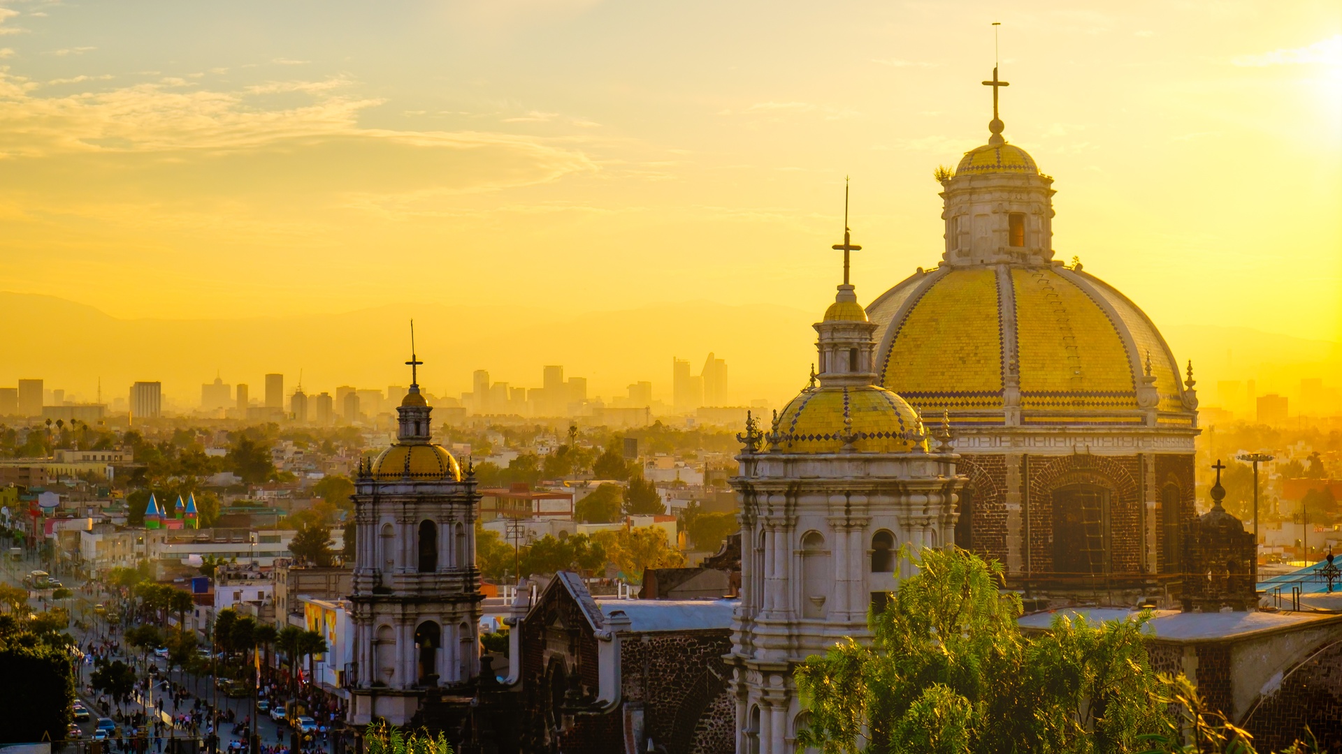 the sunset skyline of Mexico City with the Basilica of Our Lady of Guadalupe in the foreground