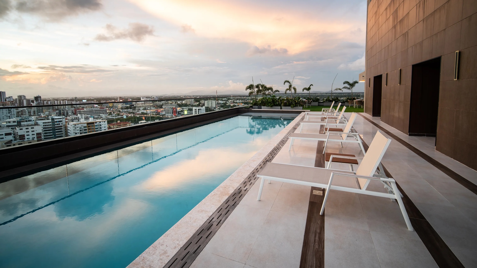 a luxurious rooftop infinity pool and lounge area at the Aston Rubi City Suites hotel in Santo Domingo.