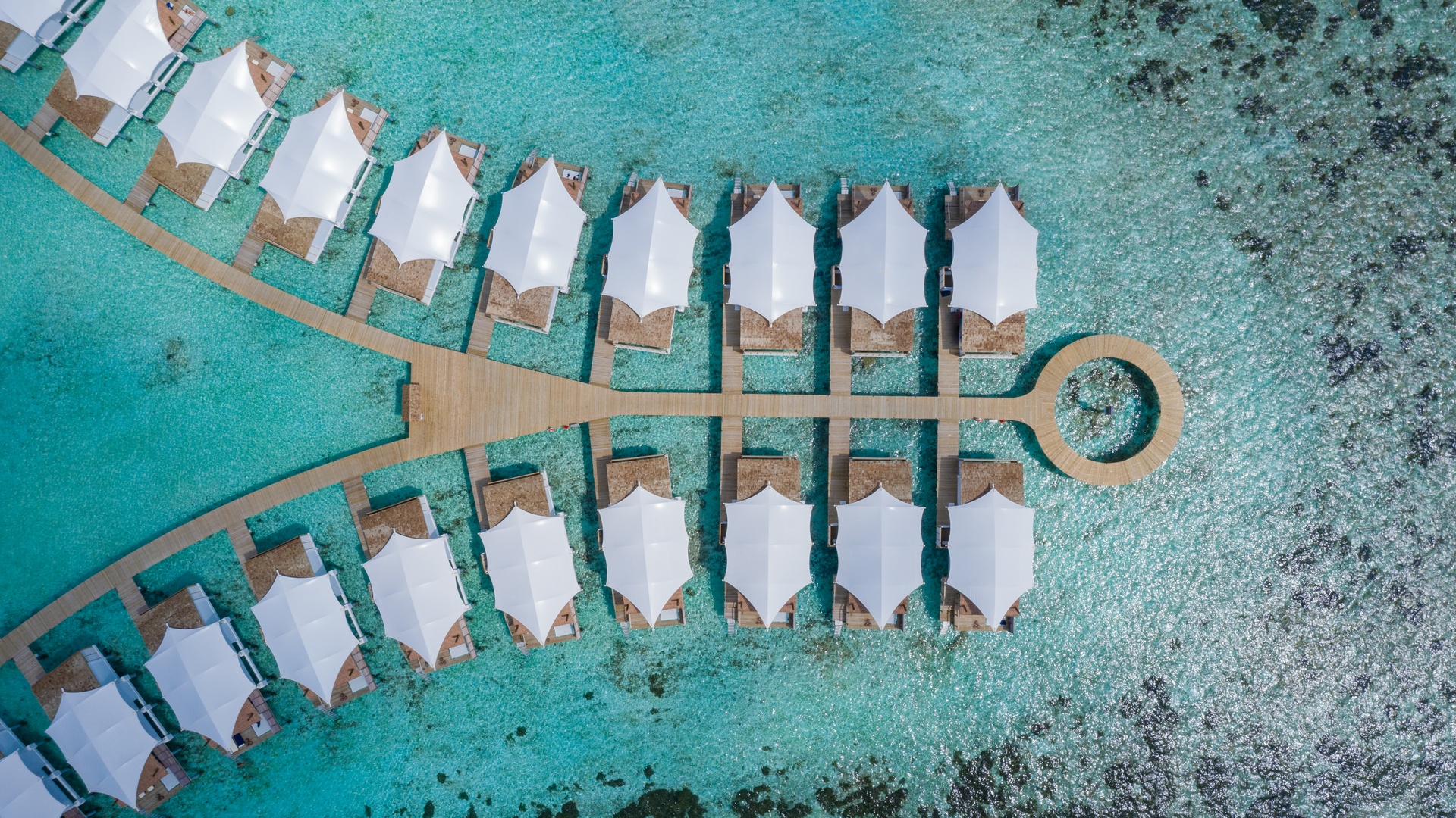 an aerial view of the overwater bungalows at the Cinnamon Hakuraa Huraa Maldives resort