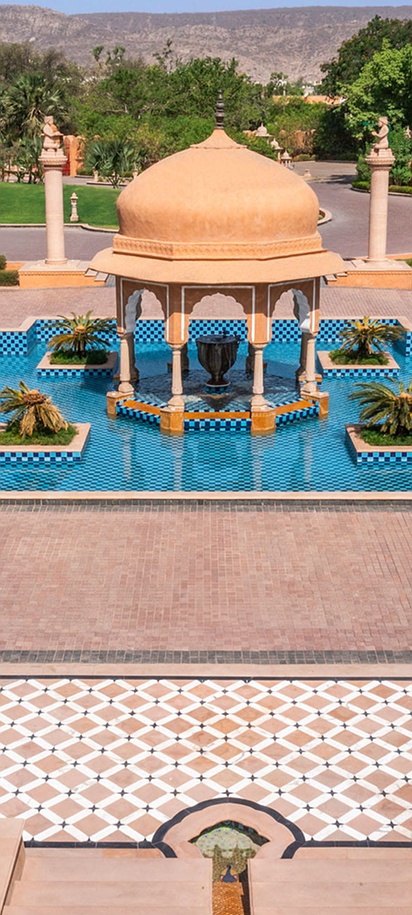 ornate central dome, reflection pool, and manicured gardens of The Oberoi Rajvilas