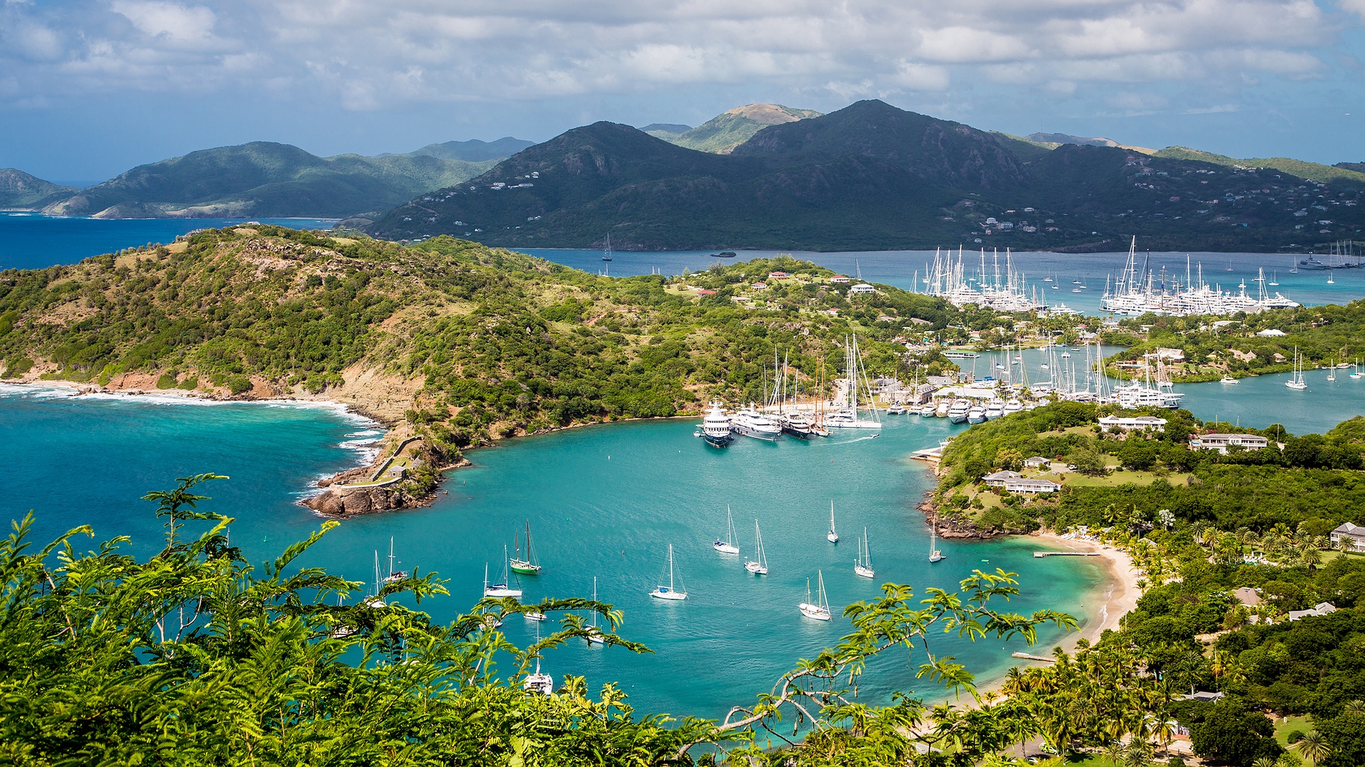 a scenic view of English Harbour and Falmouth Harbour in Antigua, likely taken from the popular viewpoint at Shirley Heights