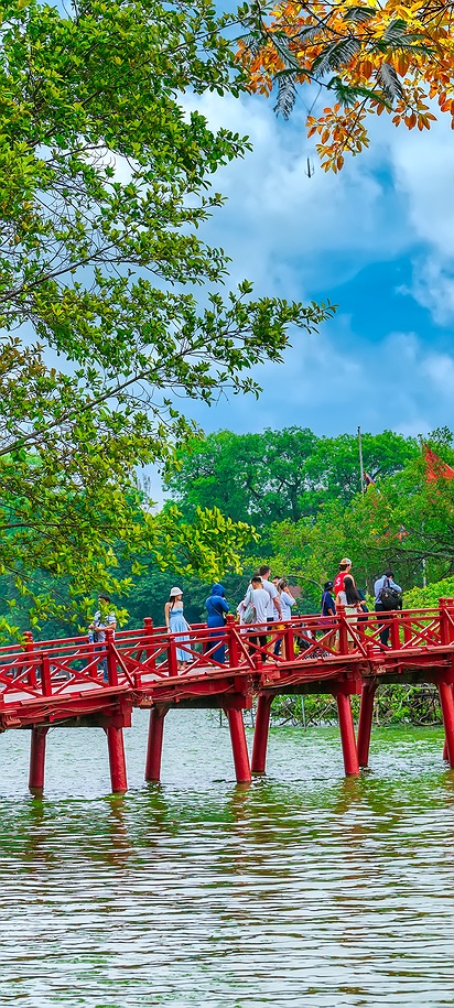 the iconic red Huc Bridge connecting the shore of Hoan Kiem Lake to the Ngoc Son Temple in Hanoi, Vietnam