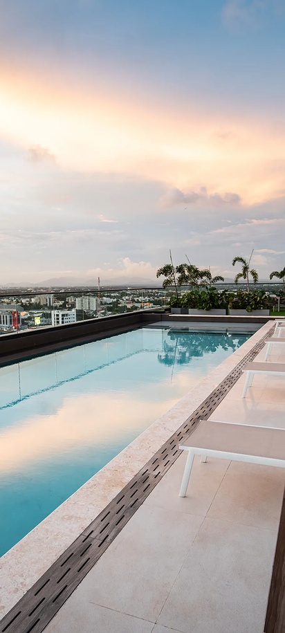 a luxurious rooftop infinity pool and lounge area at the Aston Rubi City Suites hotel in Santo Domingo.