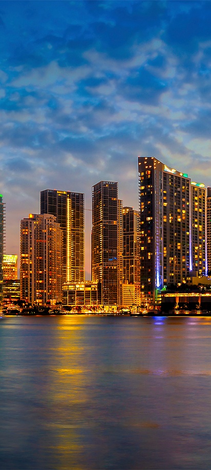 a scenic view of the Miami skyline at dusk across Biscayne Bay