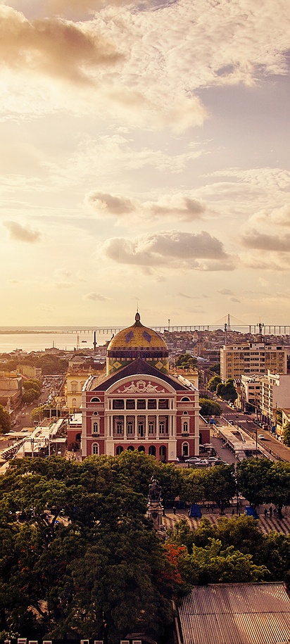 the city of Manaus, Brazil, highlighting the historic Amazon Theatre and the Rio Negro in the background