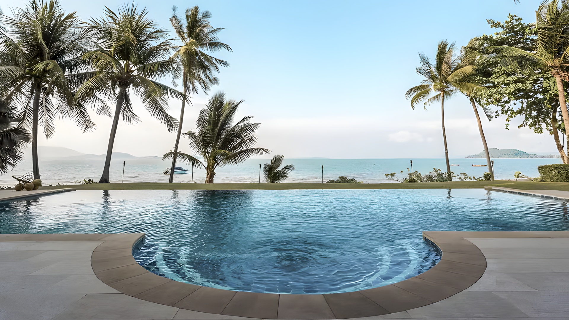  a luxury tropical resort pool overlooking the ocean at the Barceló Coconut Island resort in Phuket, Thailand