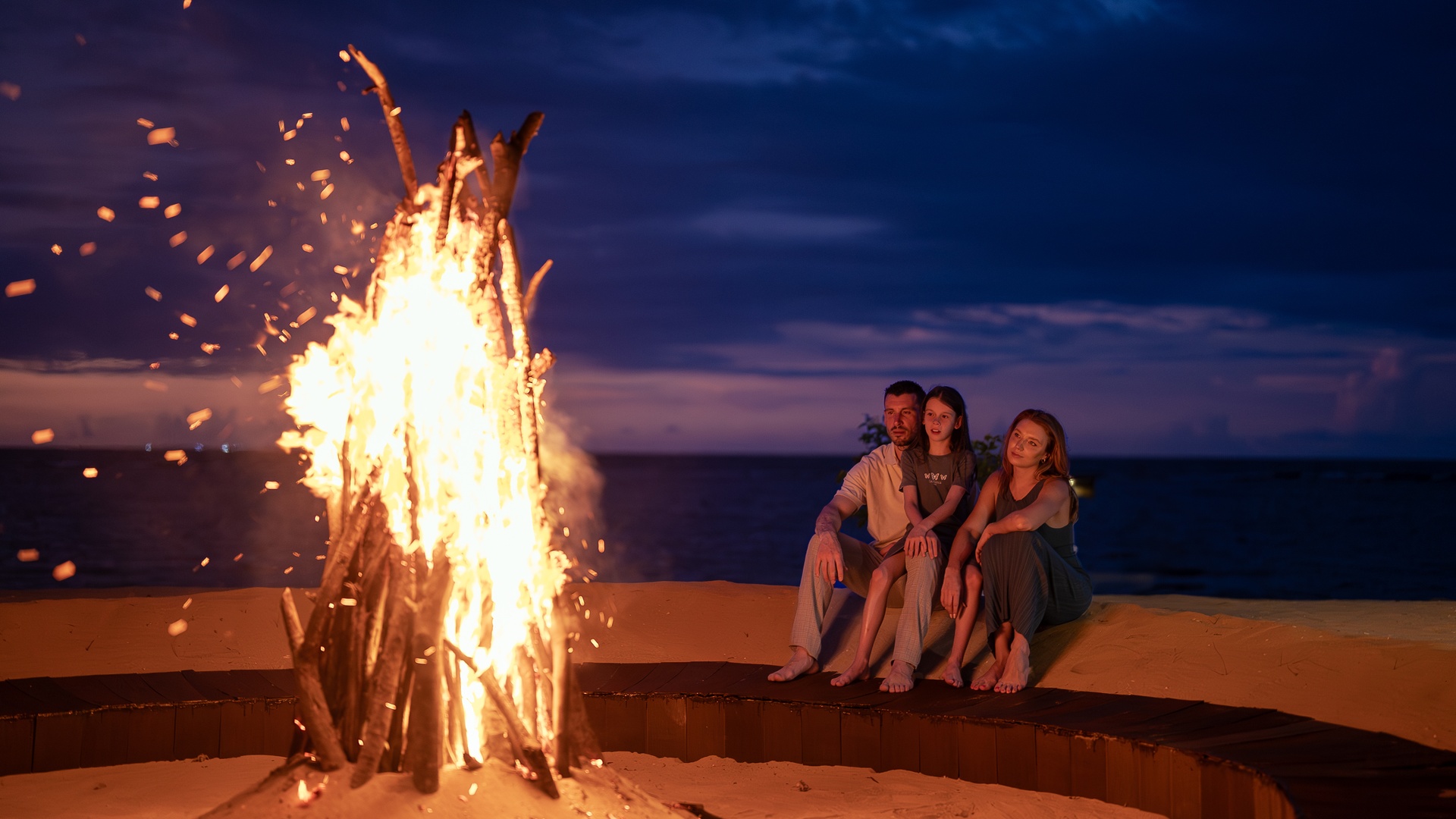  a bonfire on a beach during twilight at the Sun Siyam Pasikudah resort