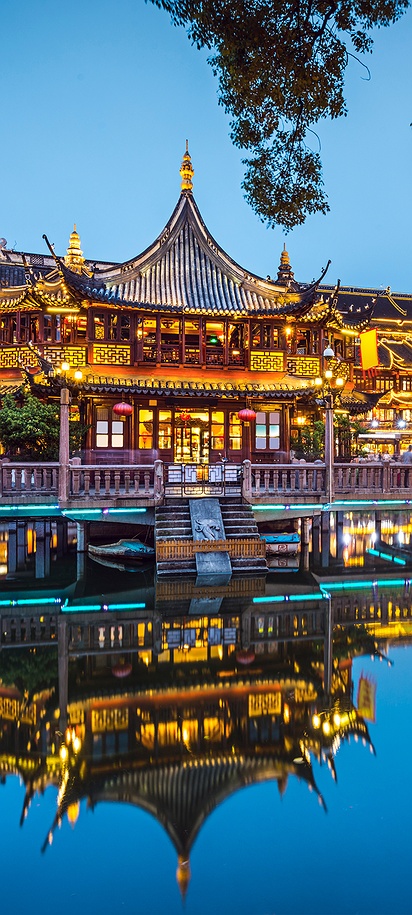 the illuminated traditional architecture of the Yu Garden in Shanghai, China, at twilight