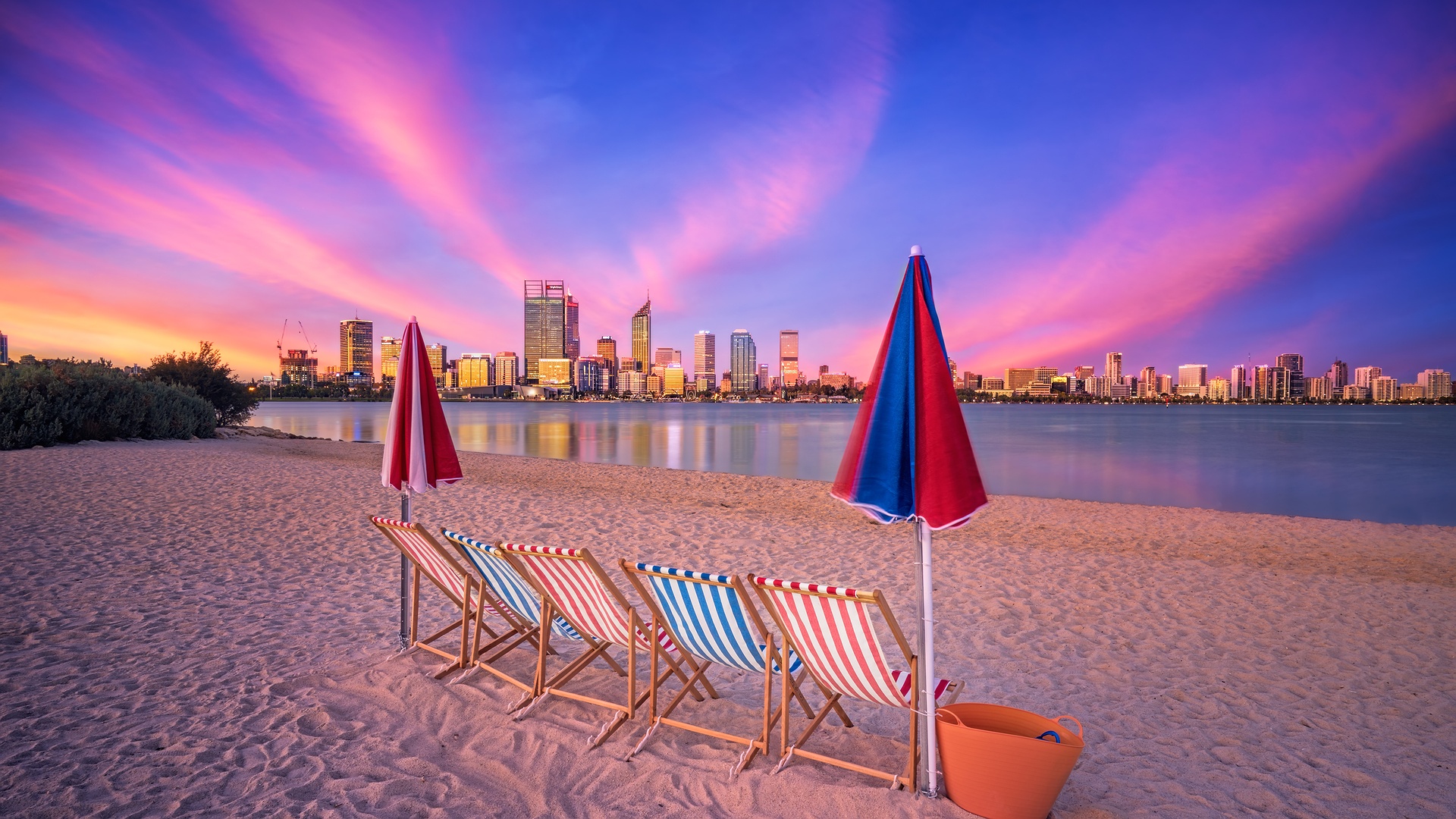 beach at sunset with a city skyline, Australia