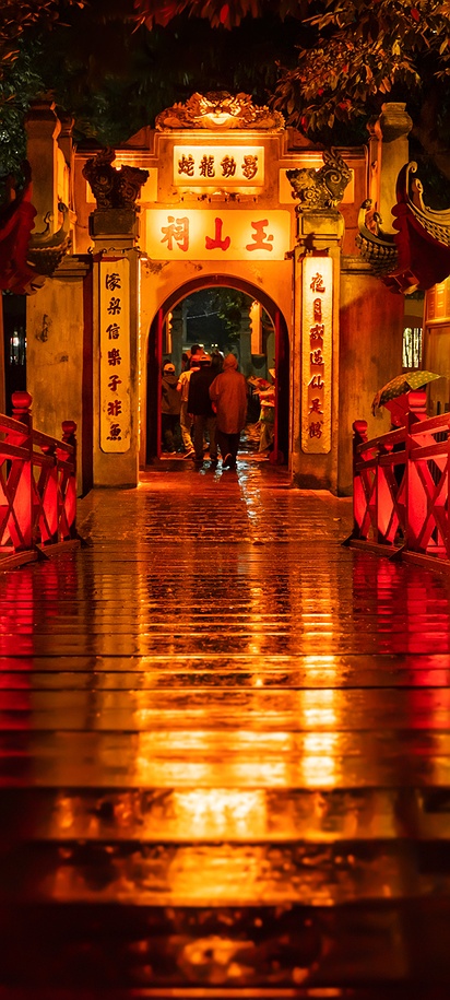 a night view of the iconic Huc Bridge (Bridge of the Rising Sun) leading to the Ngoc Son Temple in Hanoi, Vietnam