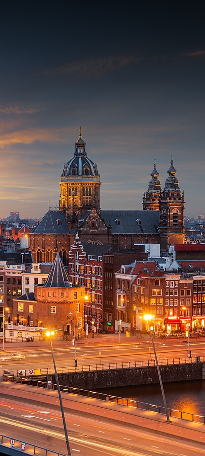 a scenic view of the Amsterdam skyline, specifically the historic city center during sunset or twilight