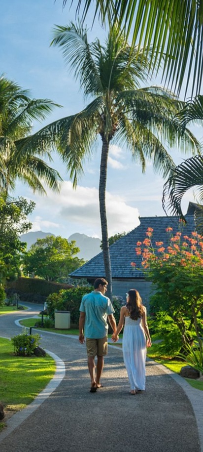 Couple walking through tropical resort gardens