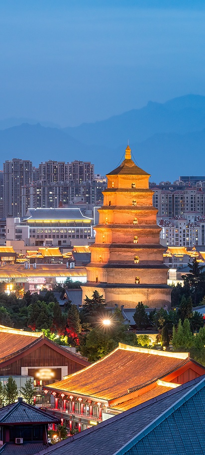 a scenic view of the Giant Wild Goose Pagoda and surrounding structures in Xi'an, China, during twilight