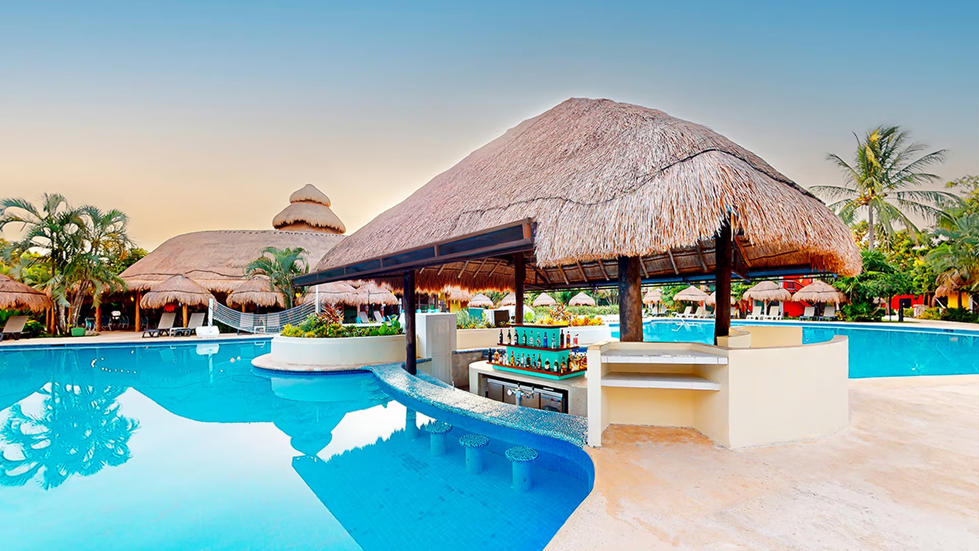 a swimming pool and a thatched-roof bar at the Iberostar Waves Cozumel resort. 