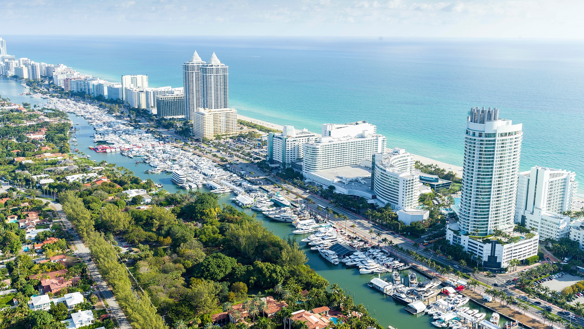 Aerial view of luxury yachts and waterfront buildings along the Miami Beach marina