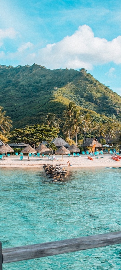 Beachfront resort with lush green mountain backdrop